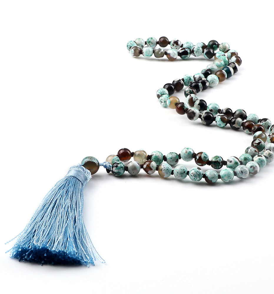 Beaded necklace with a blue tassel on a white background