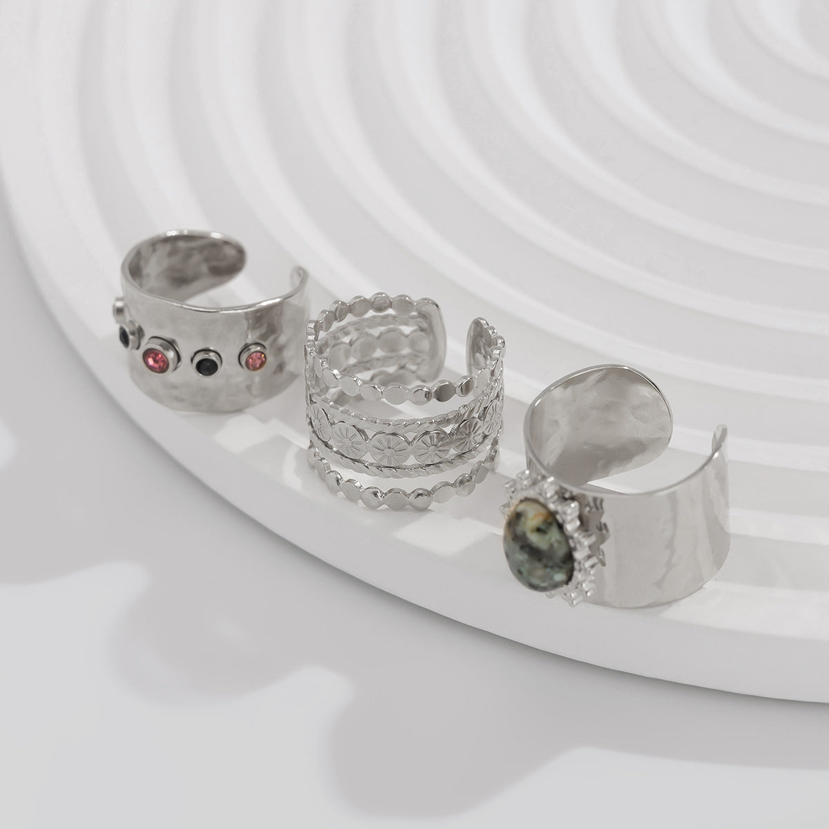 Set of silver rings with gemstones on a white plate