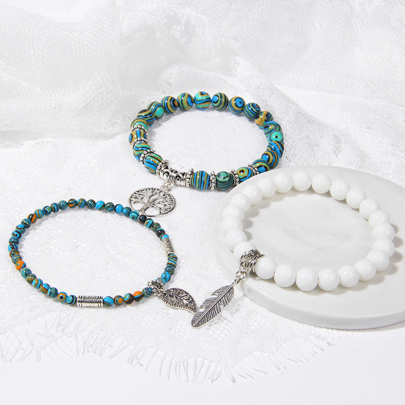Two beaded bracelets with decorative charms on a white surface