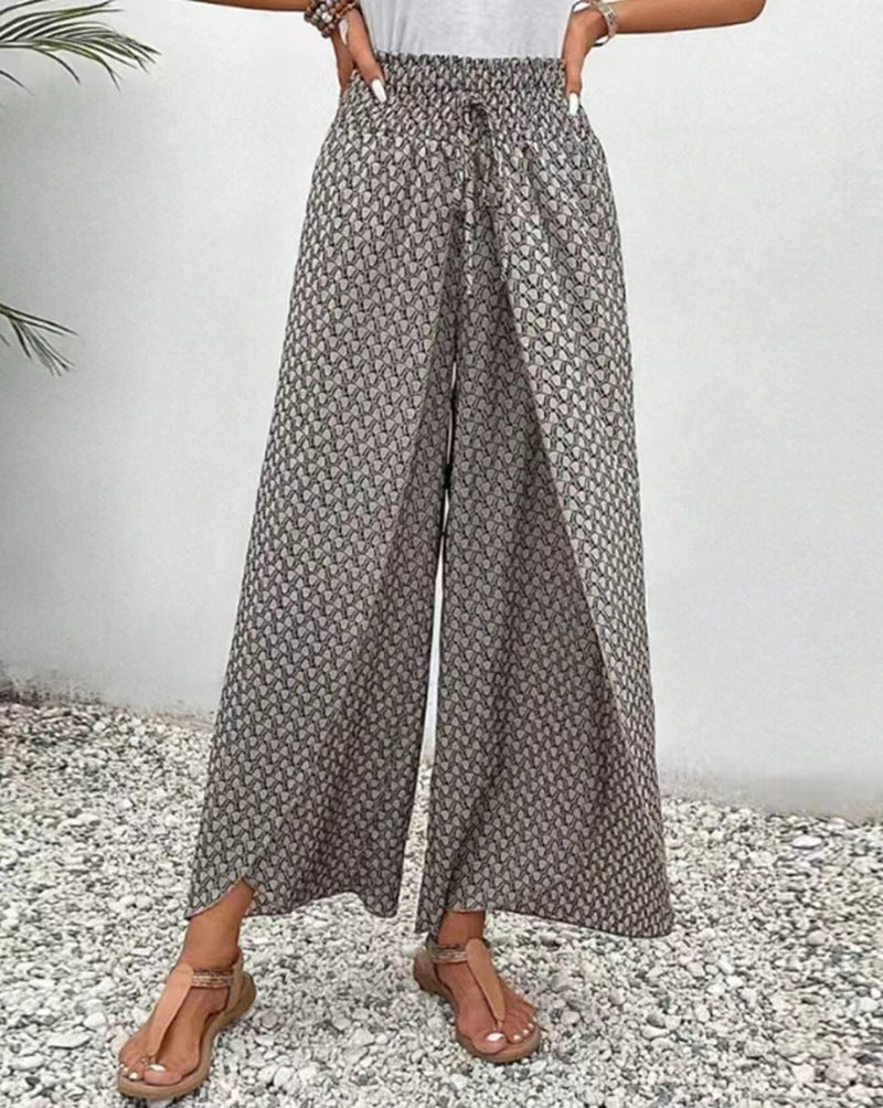 Person wearing gray floral wide-leg pants on a white background