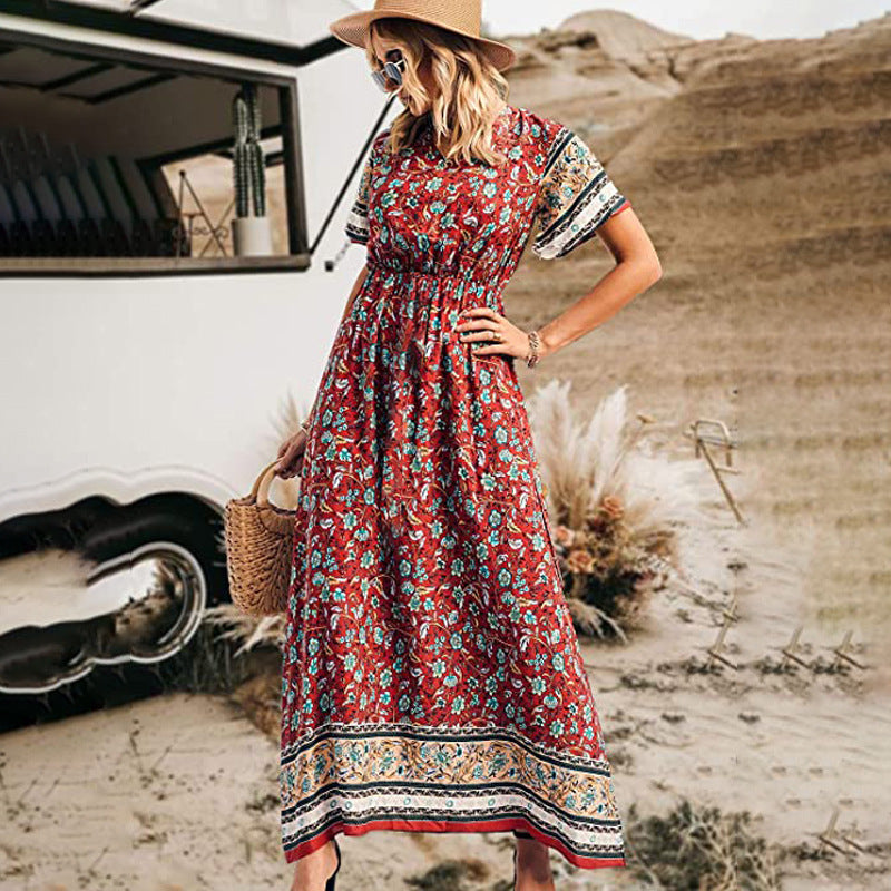 Woman in a red floral dress standing in a desert-like setting with a vintage van.