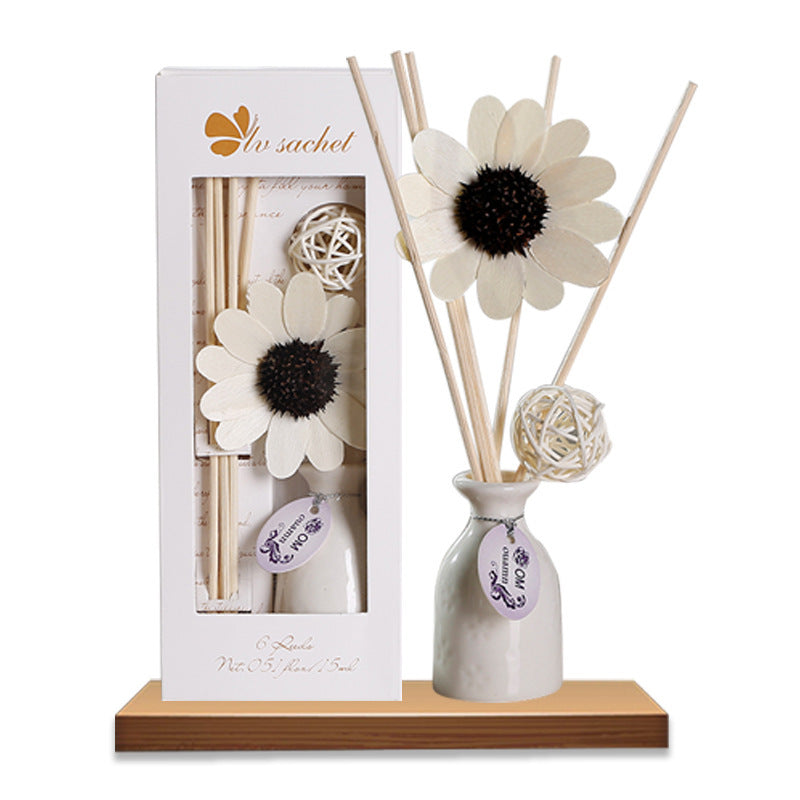 Aromatherapy diffuser set with white flowers and sticks on a wooden base, featuring the brand 'In Sachet'.