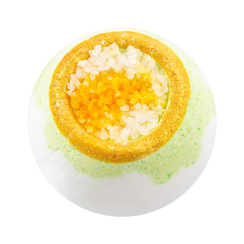 Bath bomb with a yellow center and green outer layer on a white background