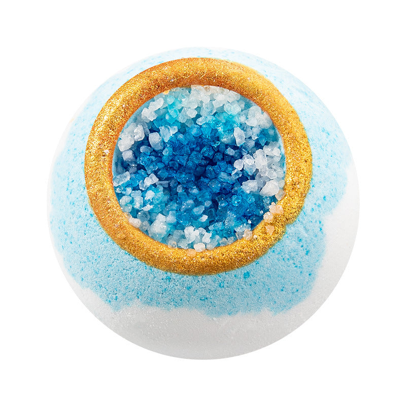 Bath bomb with blue and white interior and gold rim on a white background