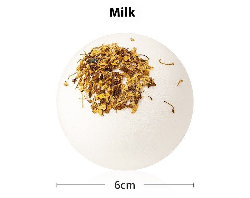 Bath bomb with milk flavor and dried herbs on a white background