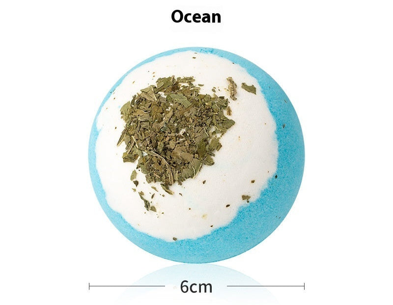 Bath bomb with ocean scent and green herbs on a white background