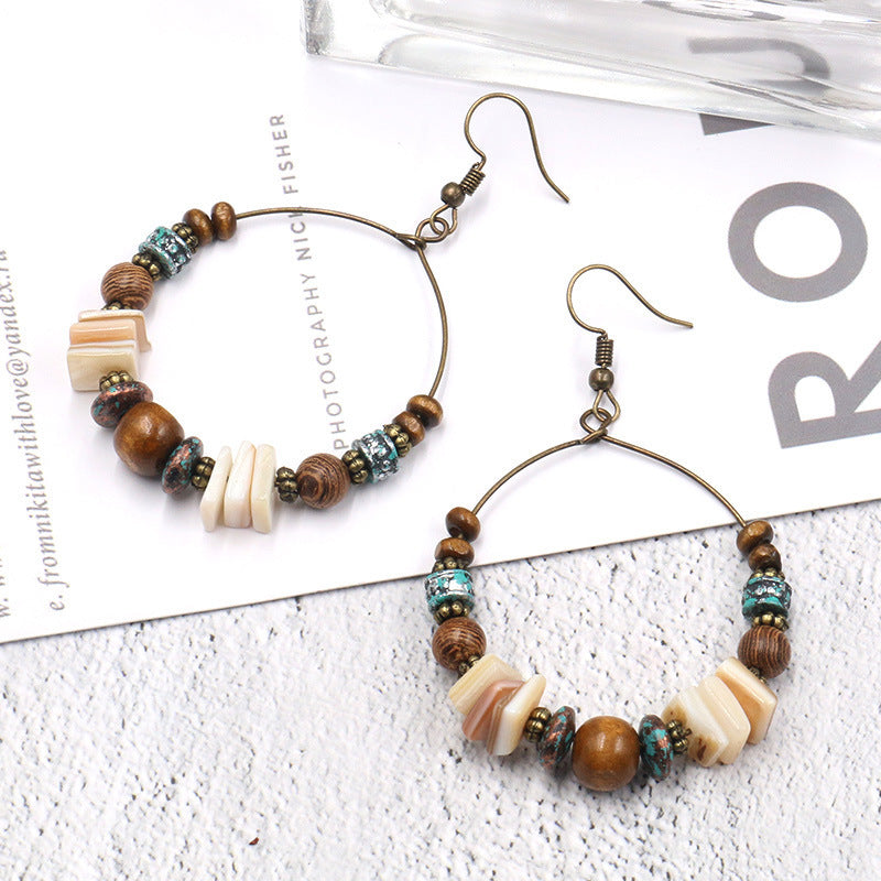 Beaded hoop earrings on a textured surface with visible text.