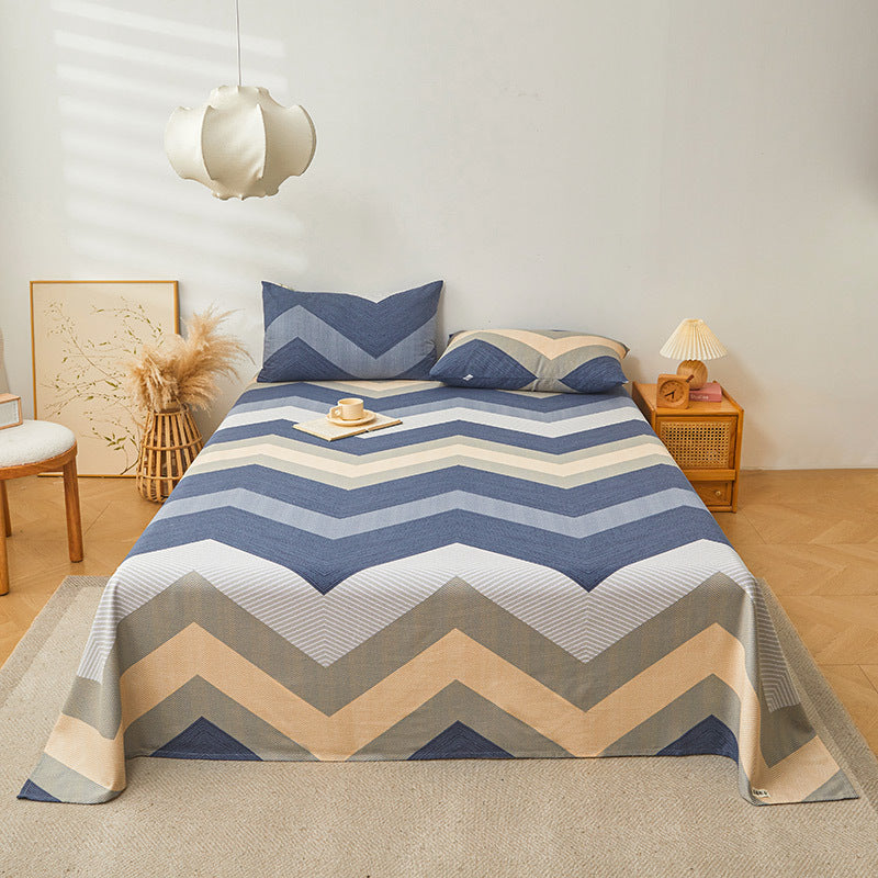 Bed with a chevron patterned comforter in a bedroom setting
