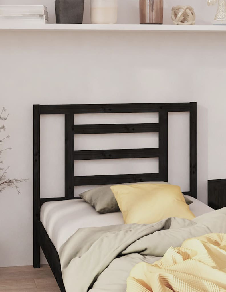 Bedroom with a black metal bed frame, white bedding, and decorative items on a shelf.