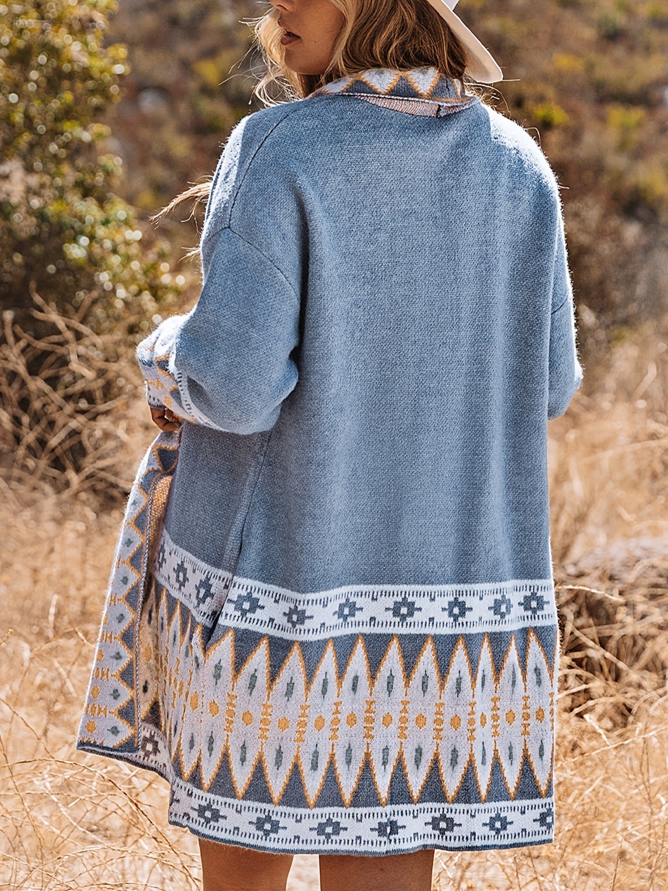 Person wearing a blue patterned jacket in a natural setting