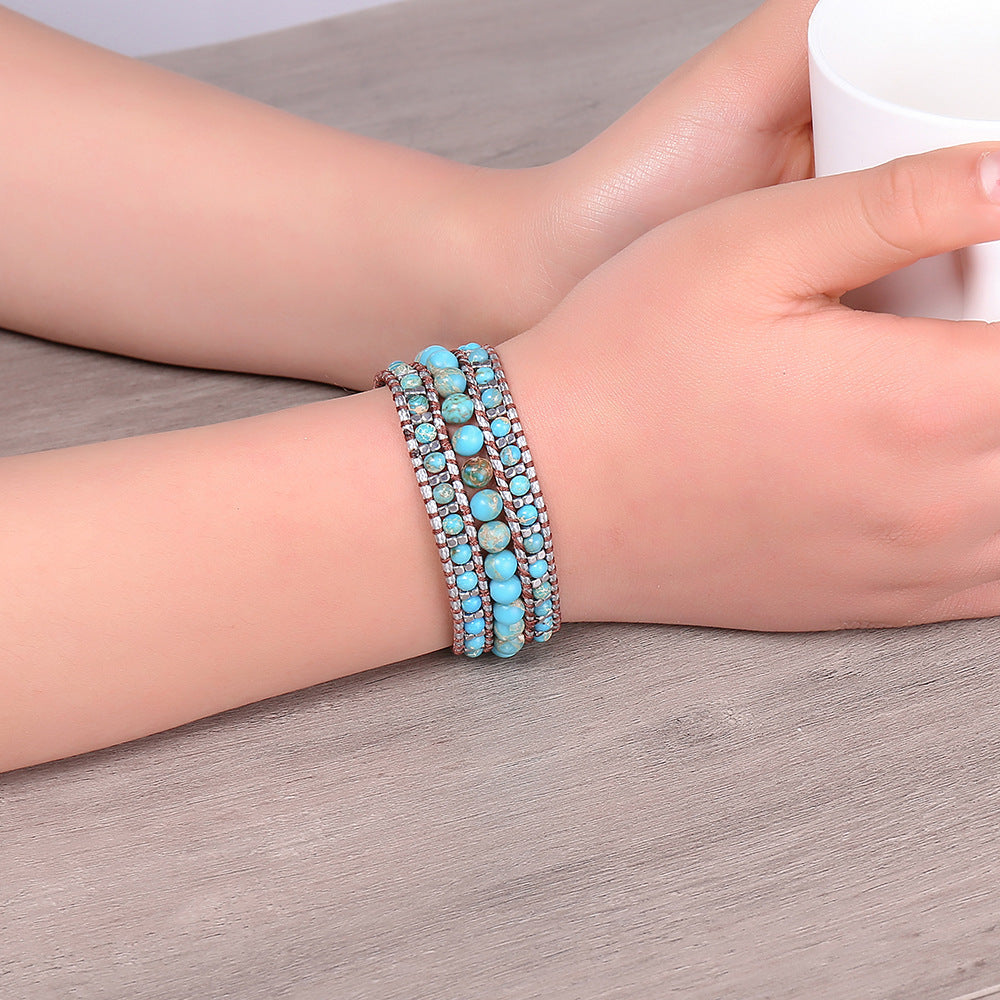 Turquoise beaded bracelet on a wrist with a neutral background