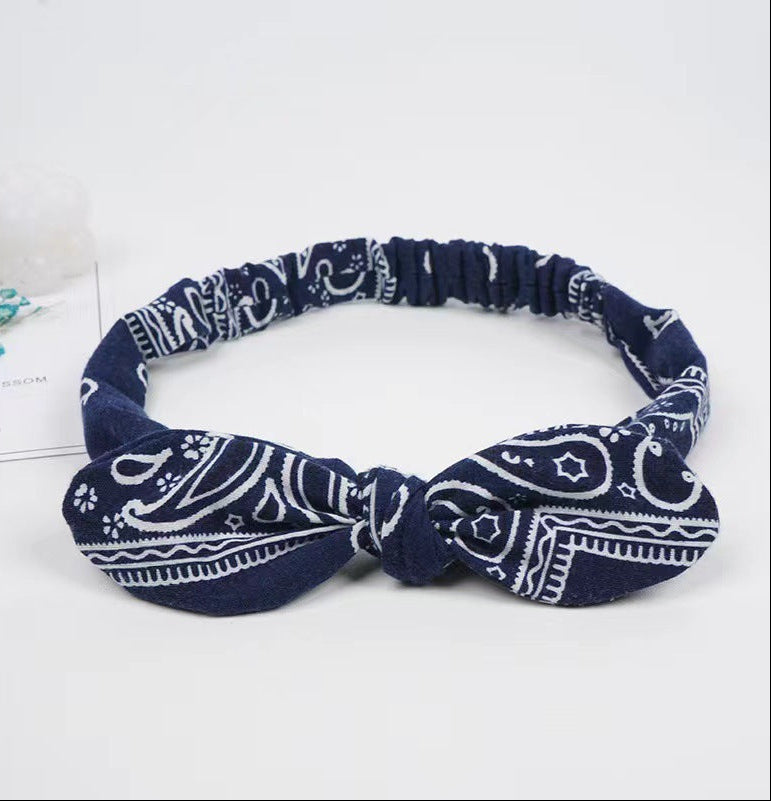 Navy blue headband with white pattern on a light gray background