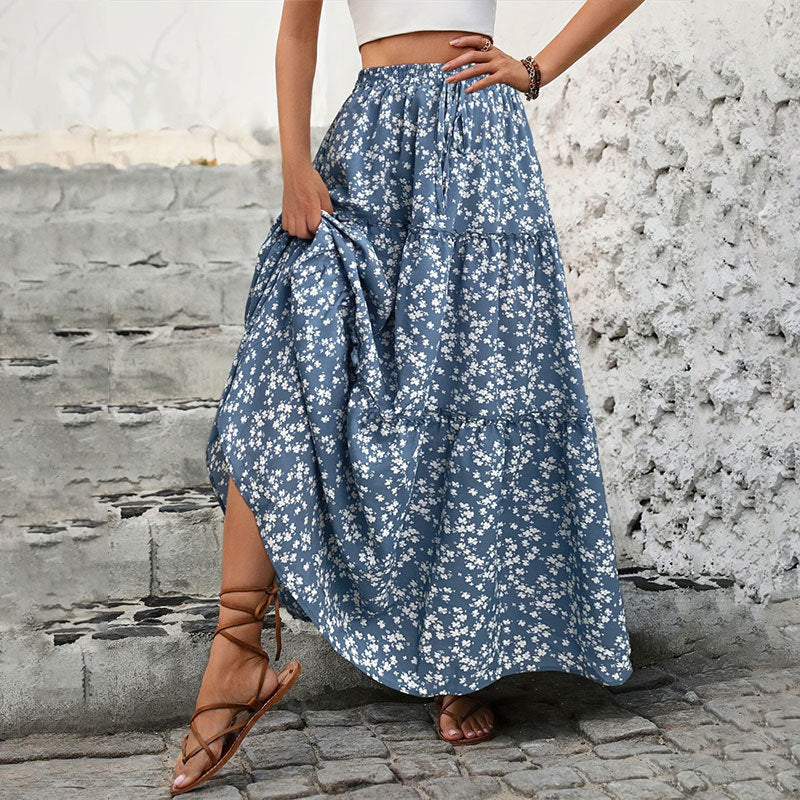 Person wearing a blue floral skirt with a white background