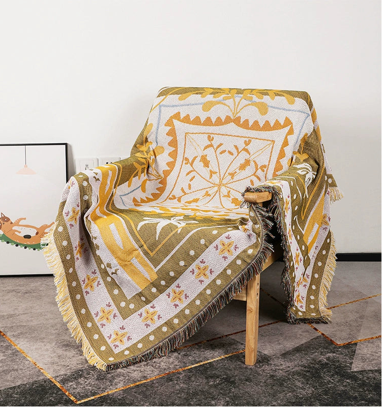 Decorative blanket with geometric pattern draped over a chair on a concrete floor.