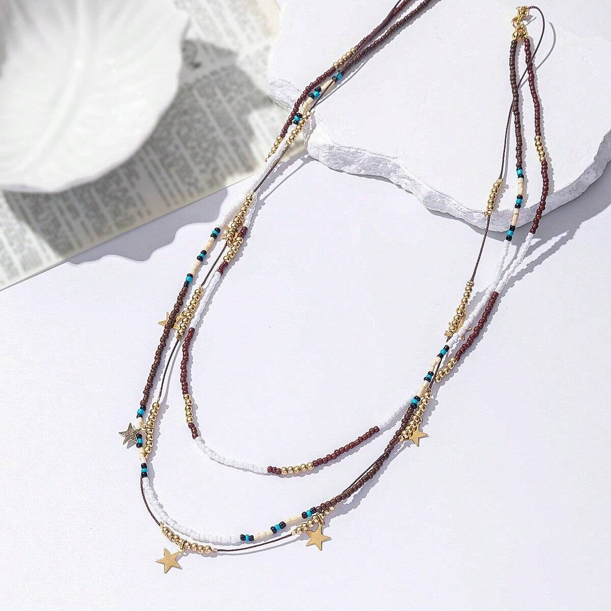 Multistrand necklace with star pendants on a light surface