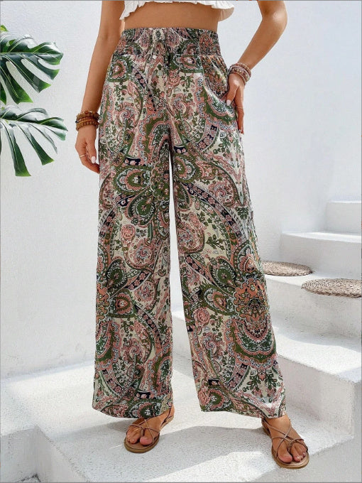Person wearing paisley patterned wide-leg pants on a white staircase.