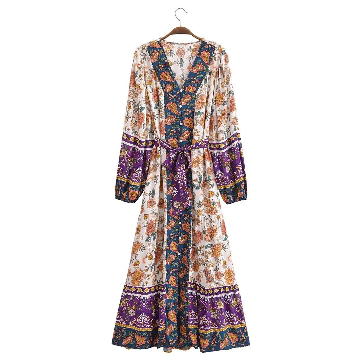 Colorful patterned dress on a hanger against a white background