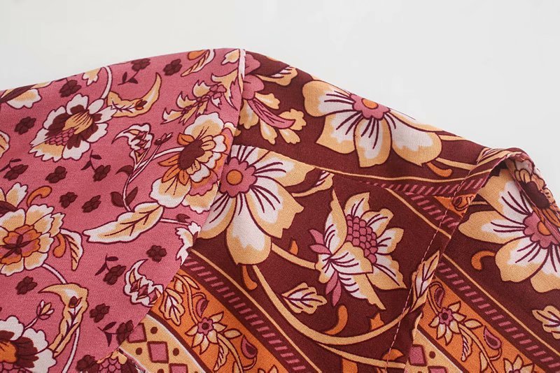 Close-up of a floral fabric with pink, brown, and orange colors on a white background.