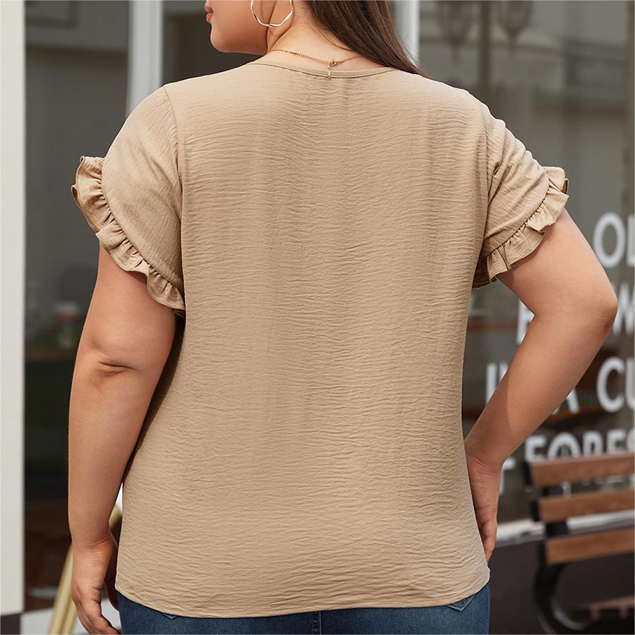 Woman wearing a beige ruffled sleeve top with a blurred background