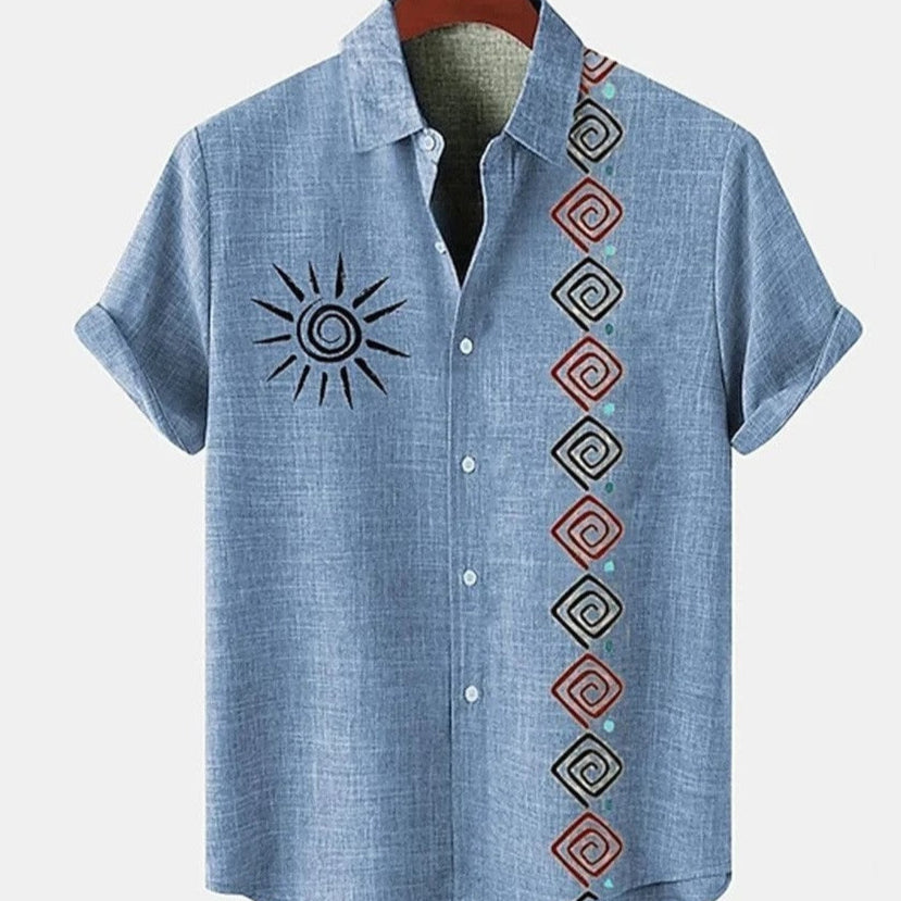 Blue shirt with sun design and geometric patterns on a hanger against a white background