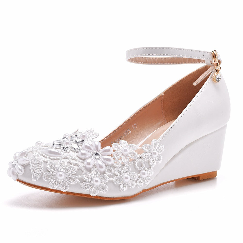 White wedge shoe with floral lace design on a white background