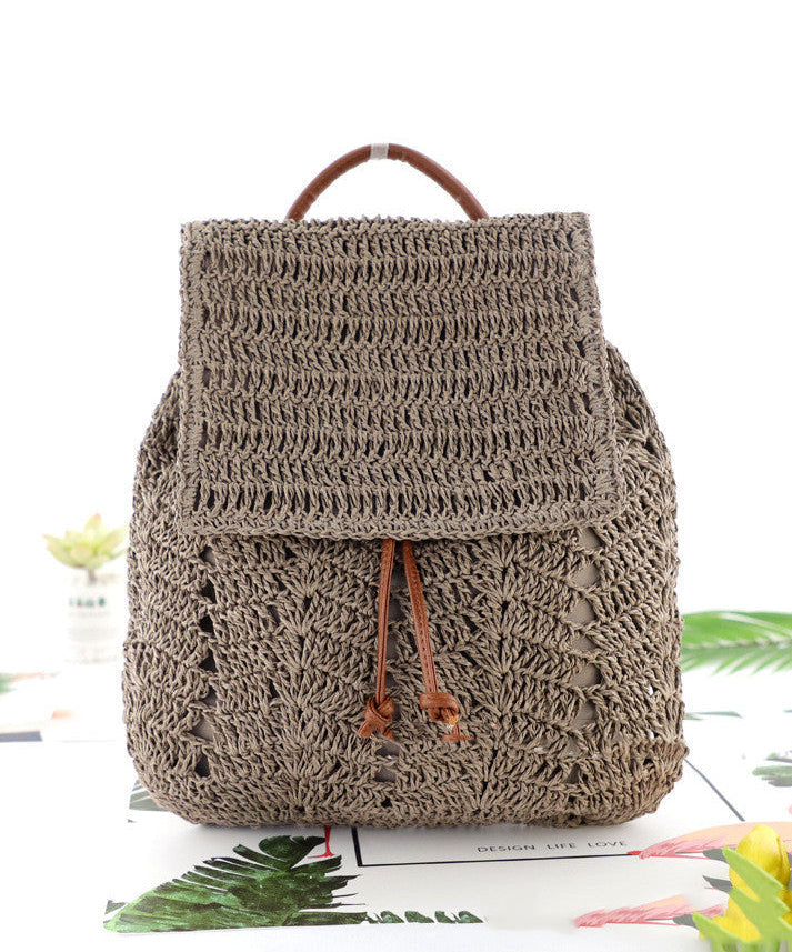 Brown crochet backpack on a white background with green leaves and flowers.