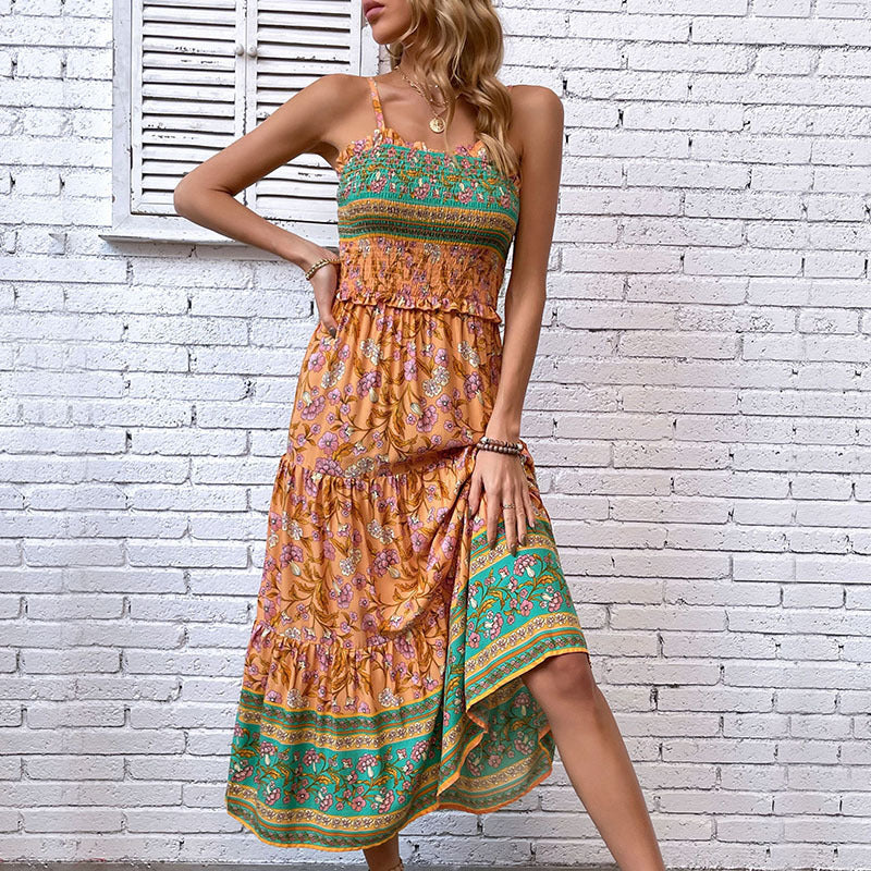 Woman wearing a colorful patterned dress against a white brick wall.