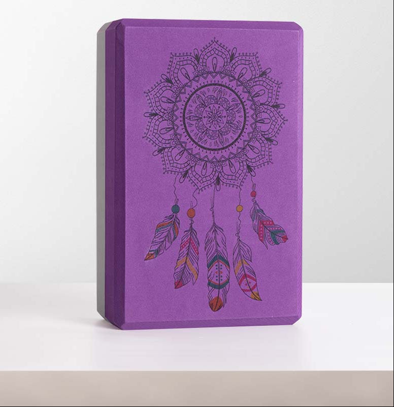 Purple yoga block with dreamcatcher design on a white background