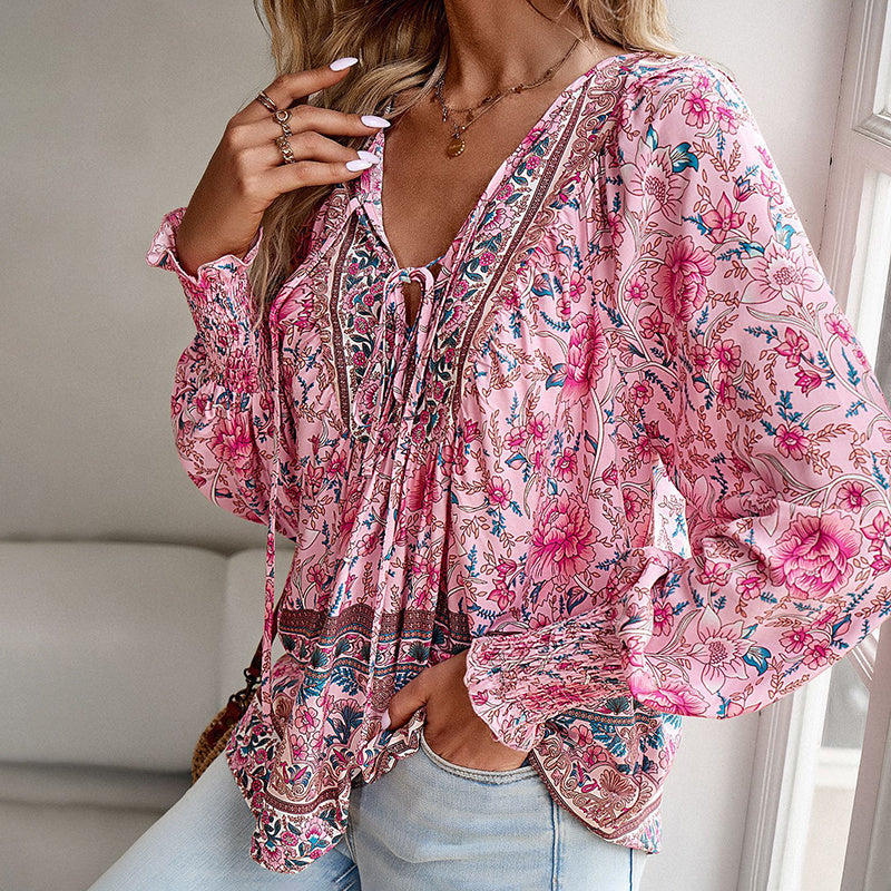 Person wearing a pink floral blouse in a bright room