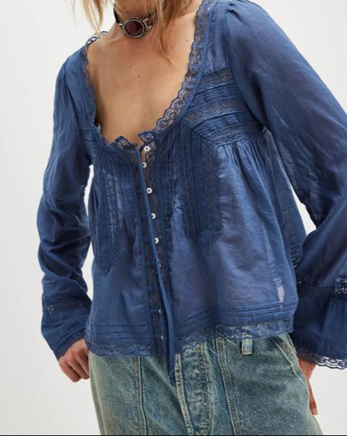 Blue lace-up top worn by a person on a white background