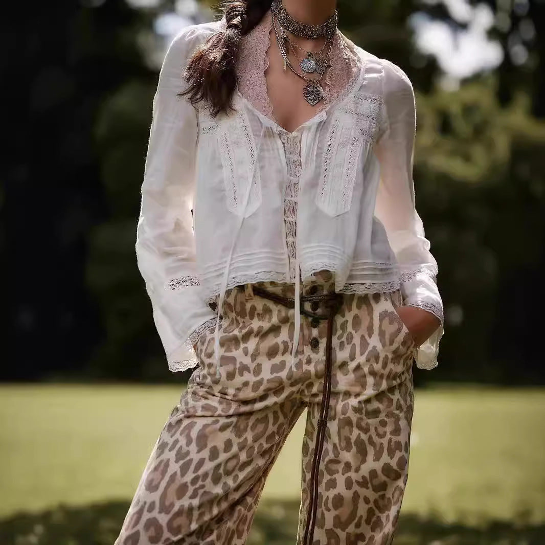 Person wearing a white blouse and leopard print pants outdoors