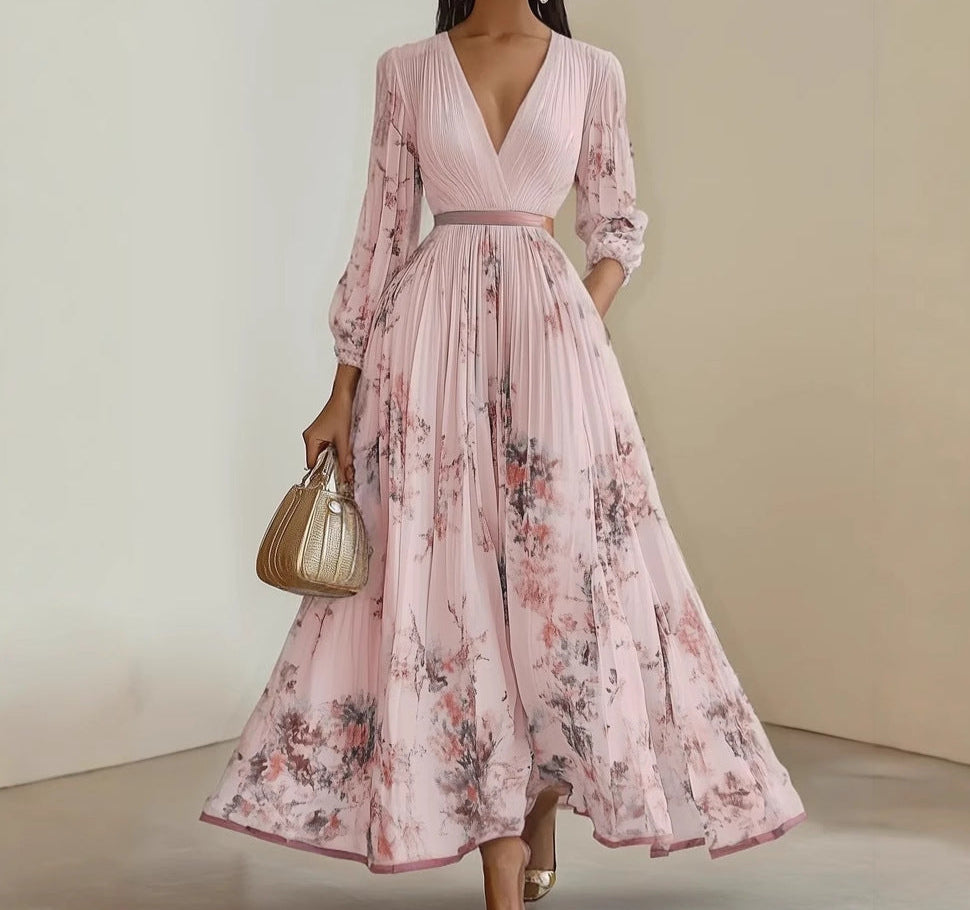 Woman wearing a pink floral dress holding a gold handbag against a neutral background