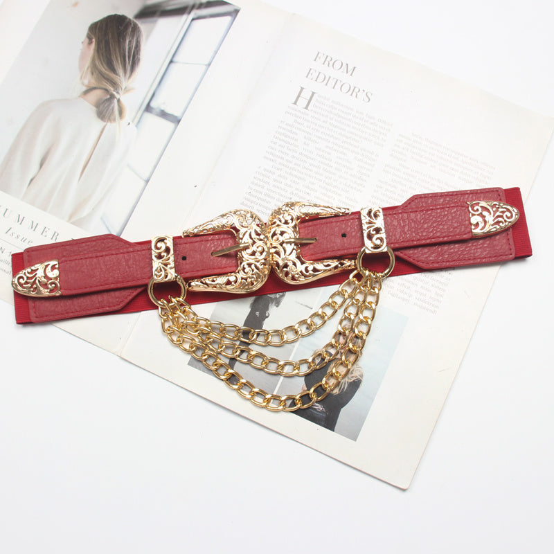 Red belt with gold chain and buckles on a magazine background