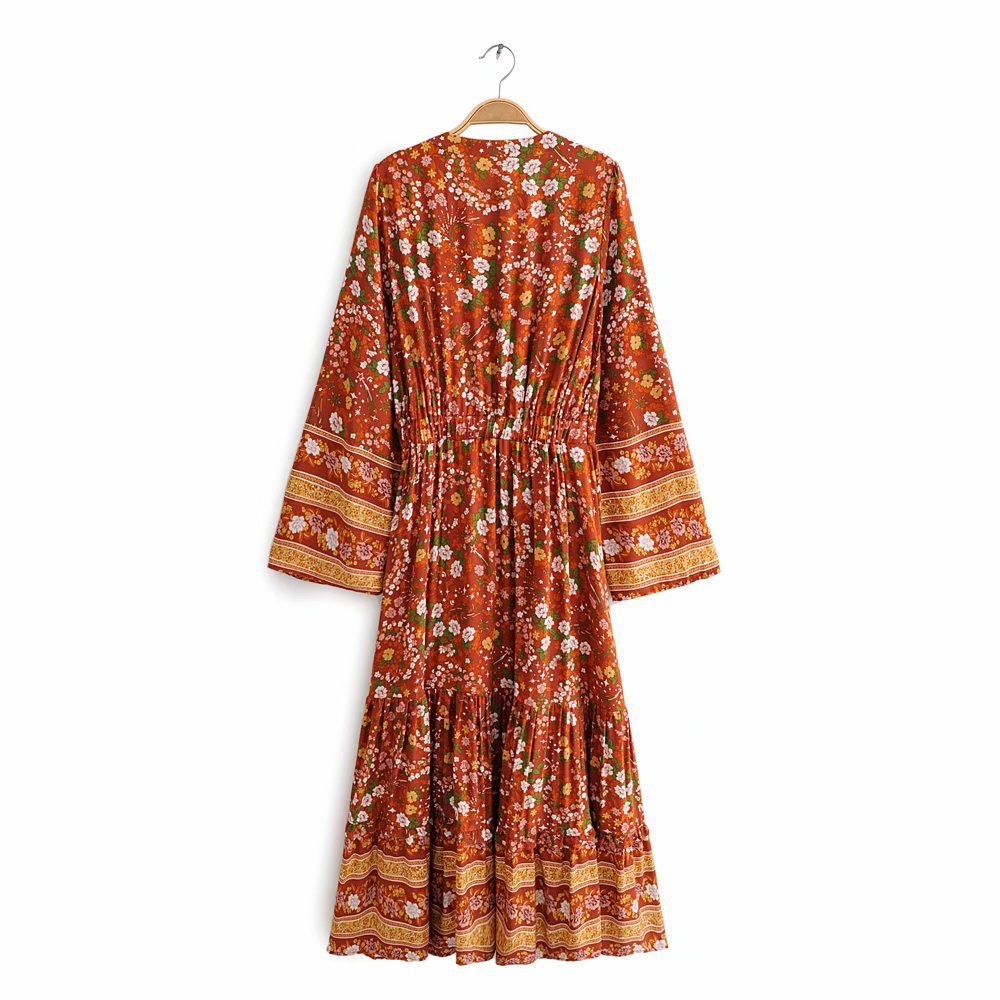 Floral patterned dress on a hanger against a white background