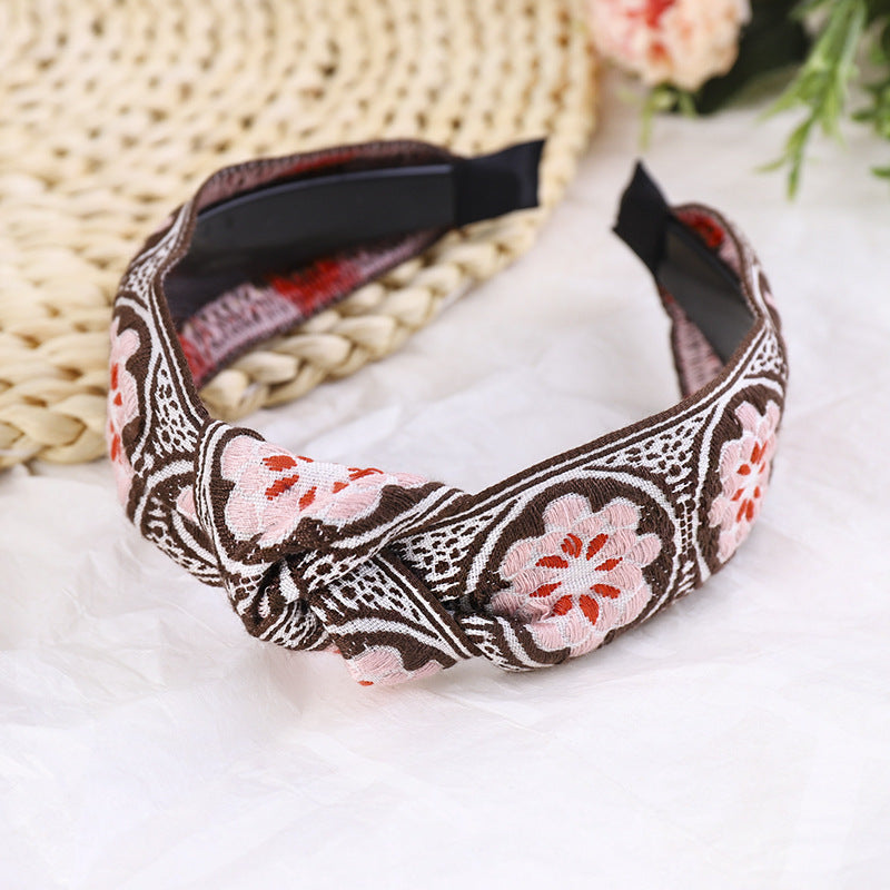 Decorative headband with floral pattern on a white surface