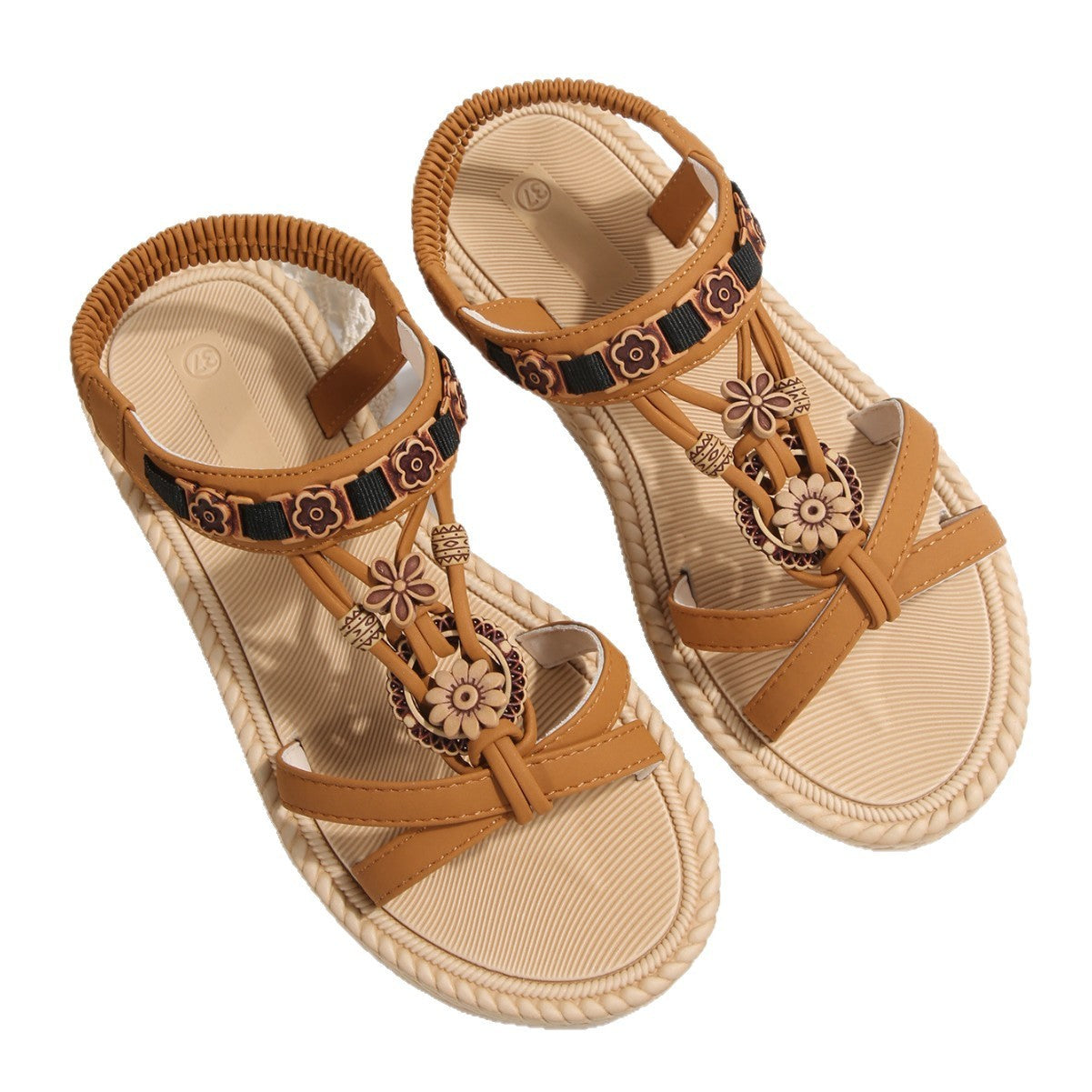 Pair of tan sandals with decorative straps on a white background