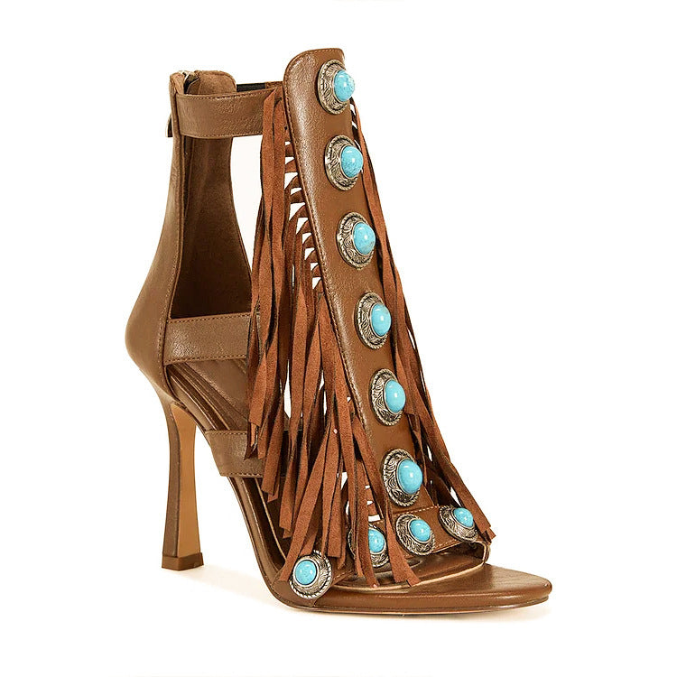 Brown high-heeled sandal with fringes and turquoise embellishments on a white background