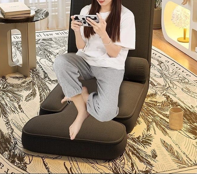 Woman sitting on a brown cushioned chair in a room with a rug and decor.