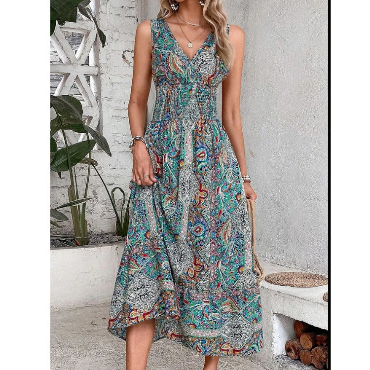 Woman wearing a floral dress in a casual setting with plants and a white wall.