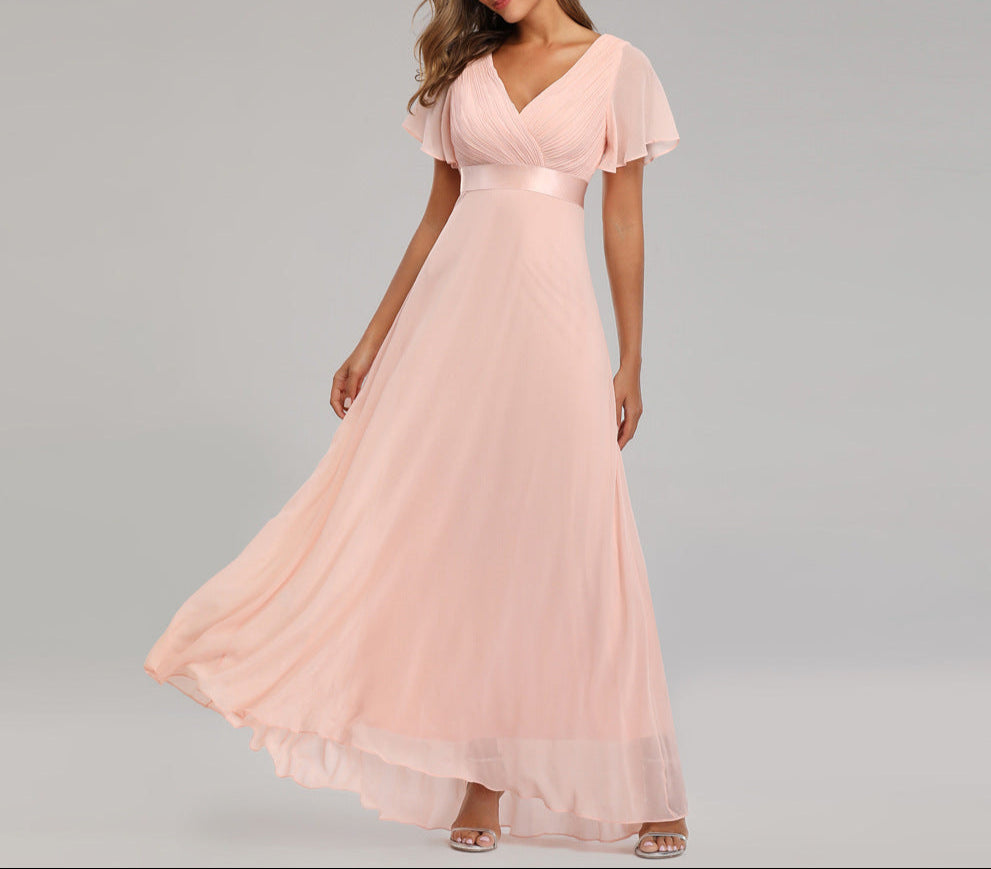 Woman wearing a pink evening gown on a gray background