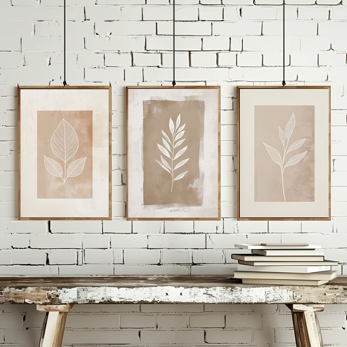 Three leaf prints on a white brick wall with a wooden table below.