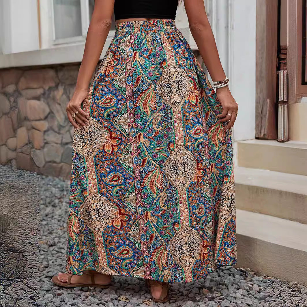Person wearing a colorful patterned skirt standing on a stone path.