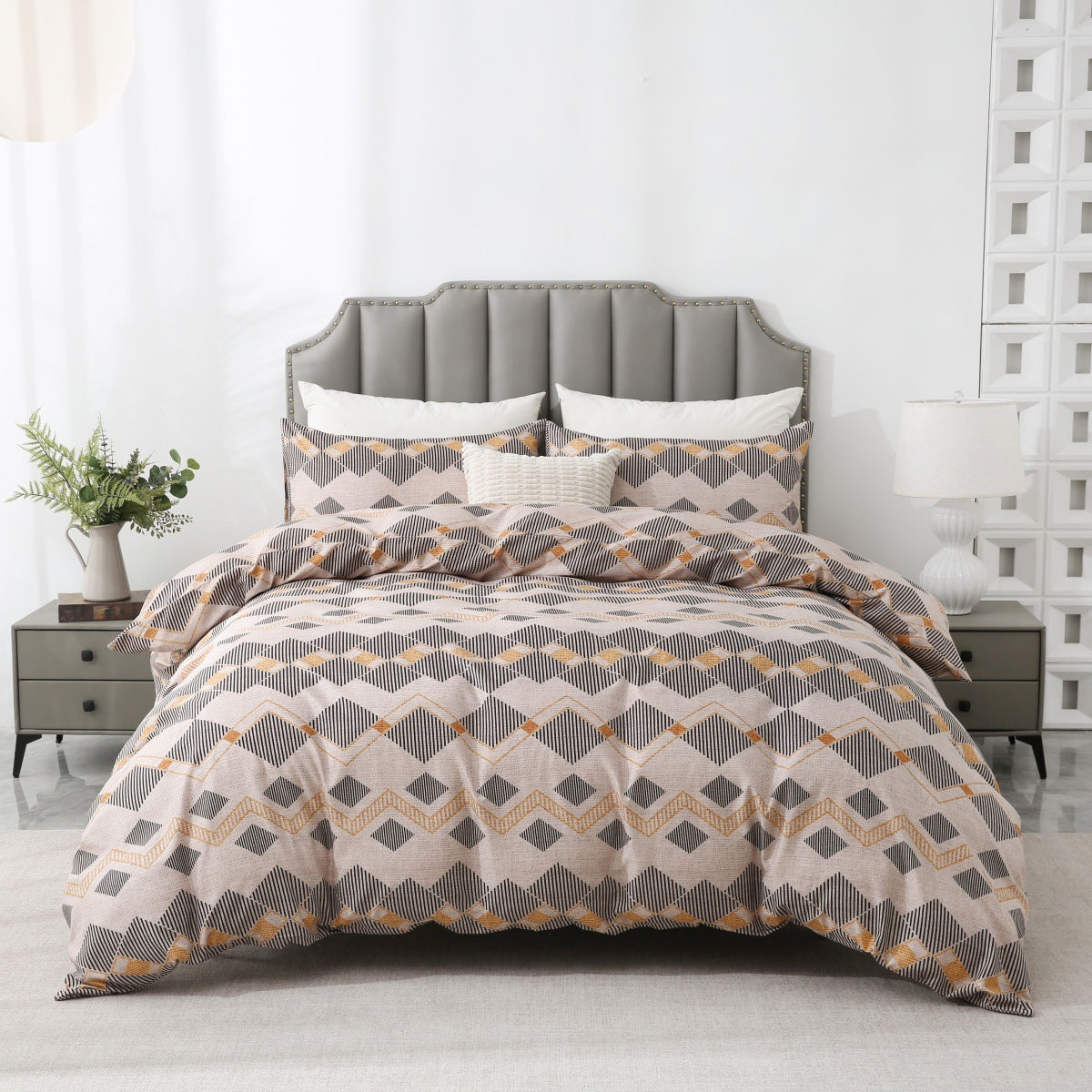 Bed with geometric patterned comforter in a modern bedroom setting