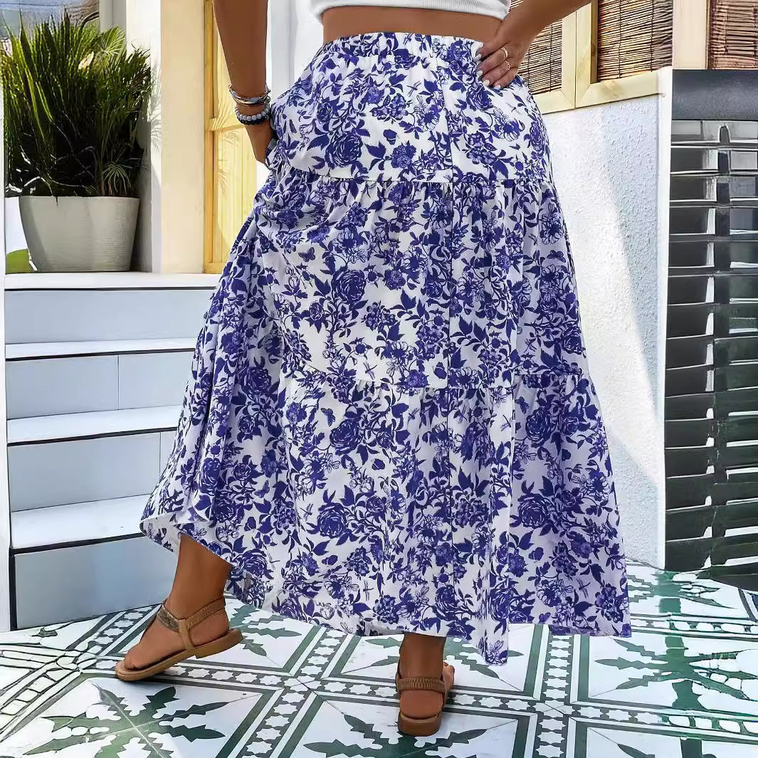 Person wearing a blue floral skirt standing on a patterned floor.