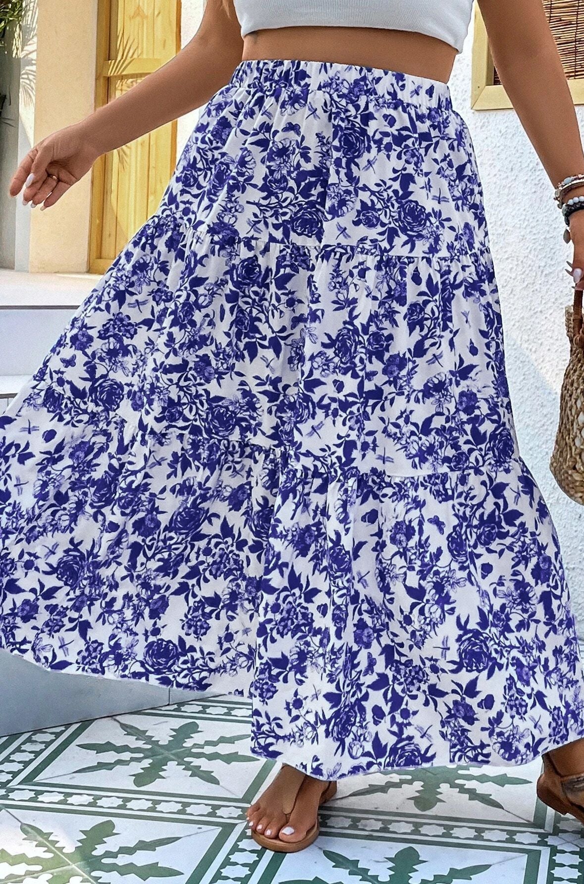 Person wearing a blue floral skirt with a white background