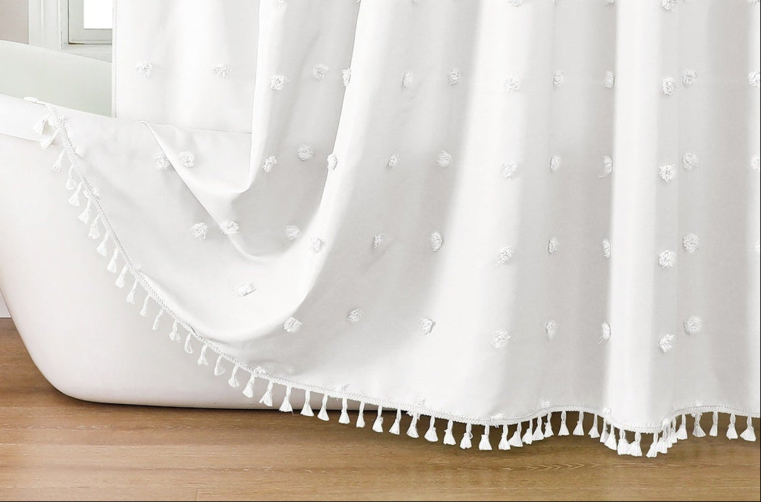 White shower curtain with tassels in a bathroom setting