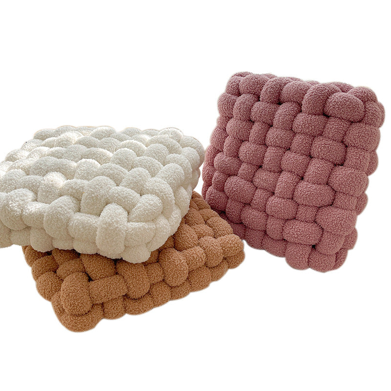 Three woven coasters in white, brown, and pink on a white background