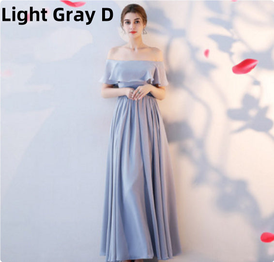 Woman wearing a light gray off-shoulder dress with a blurred background