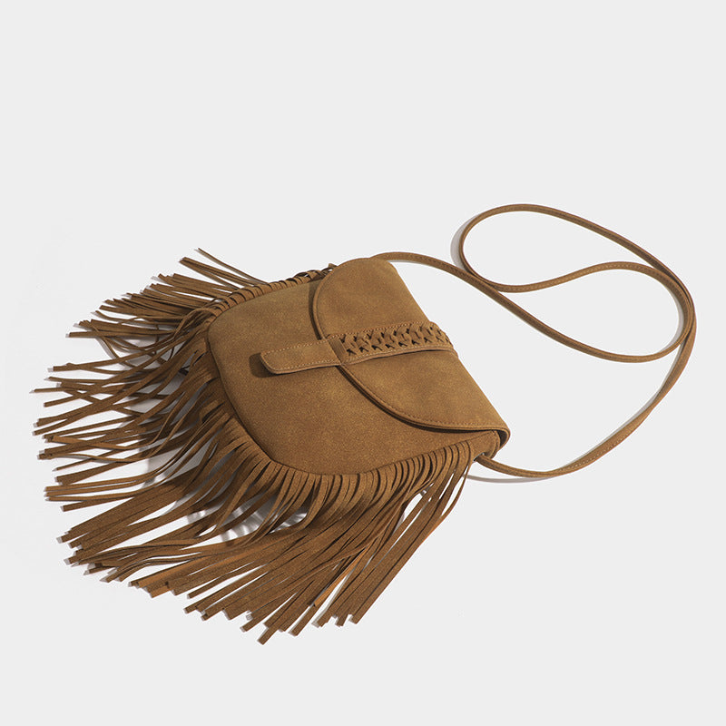 Brown suede handbag with fringe details on a light gray background