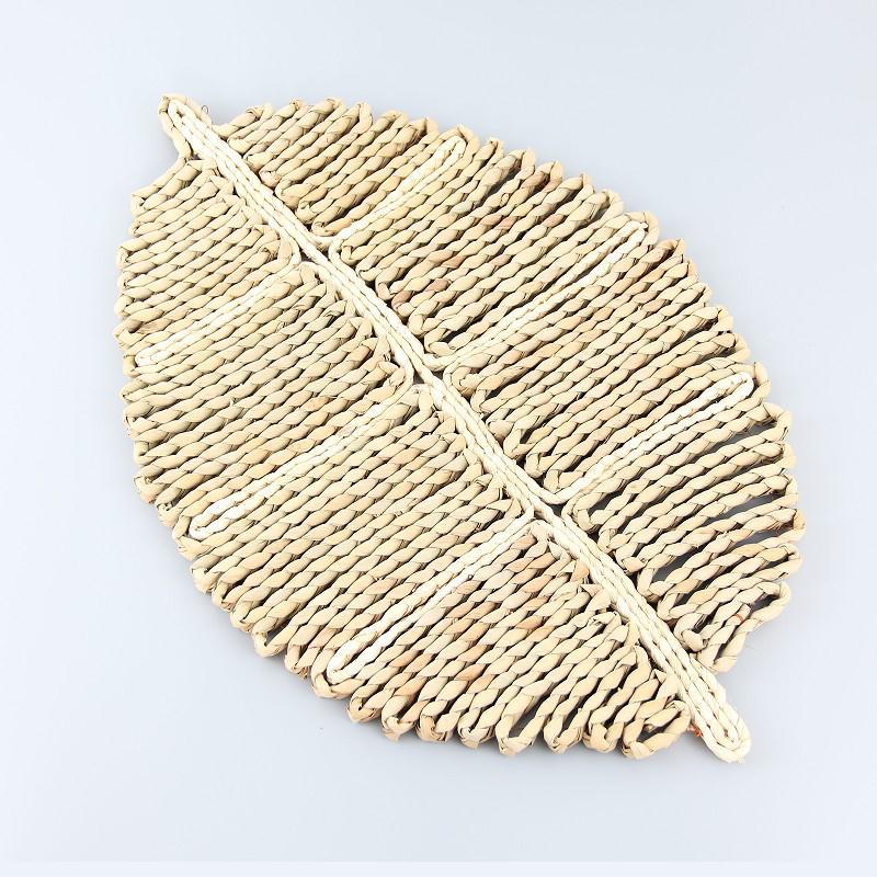 Woven leaf-shaped mat on a light gray background